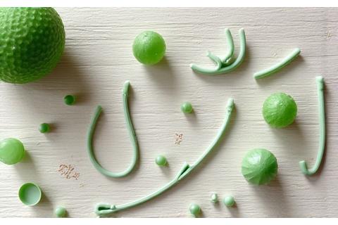 A collection of small, green-tinted biodegradable fishing accessories like indicators, stoppers, and small tools scattered on a light-colored workbench.